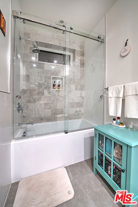 bathroom featuring combined bath / shower with glass door and tile patterned floors