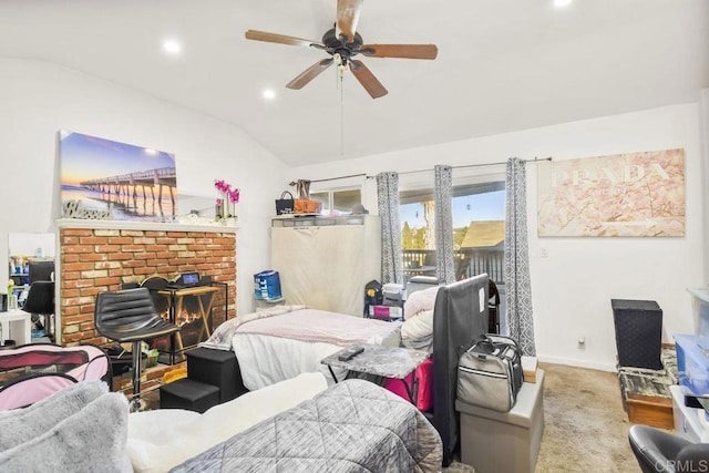 bedroom with a fireplace, light colored carpet, vaulted ceiling, and ceiling fan