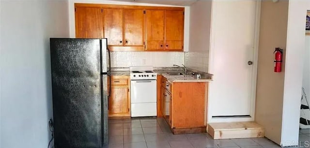 kitchen featuring tasteful backsplash, sink, fridge, electric range, and light tile patterned floors