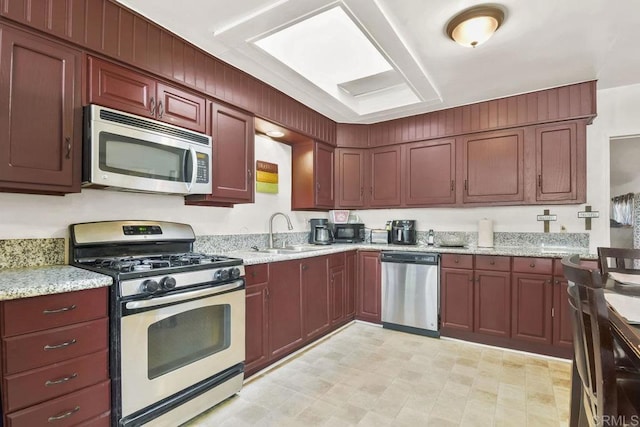 kitchen with light stone countertops, sink, and stainless steel appliances