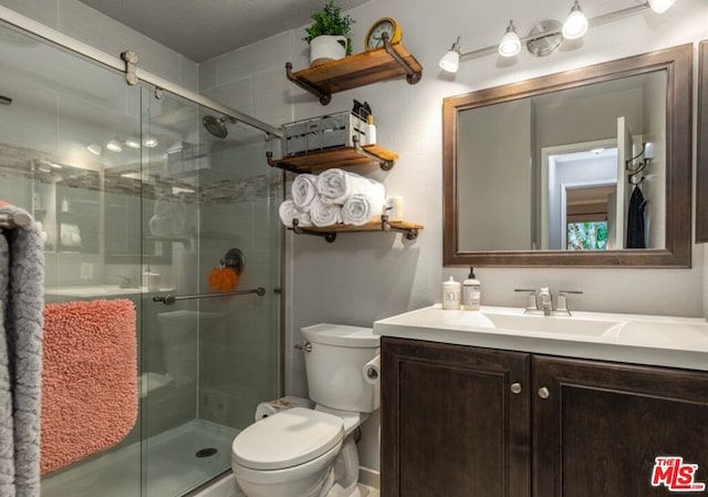 bathroom with toilet, walk in shower, and vanity