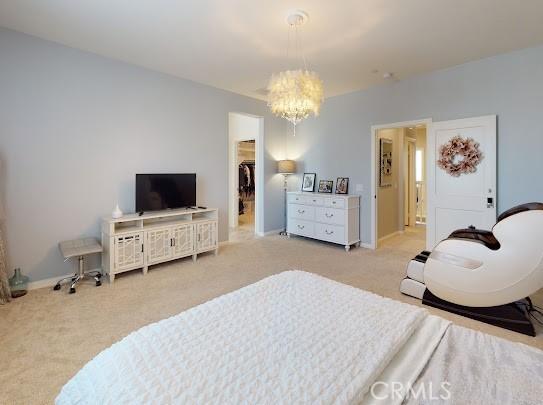 bedroom with light colored carpet, a closet, and an inviting chandelier