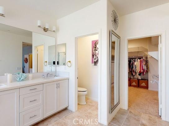 bathroom with toilet, tile patterned floors, and vanity