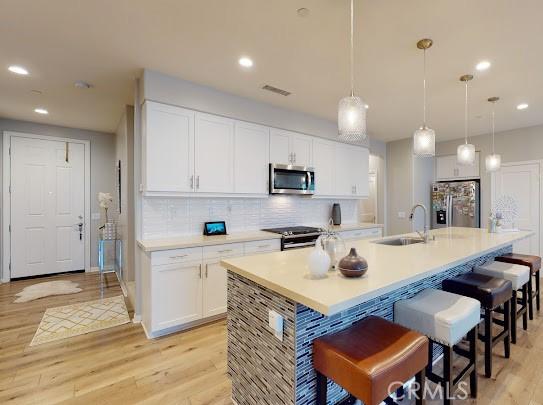 kitchen with sink, white cabinets, and stainless steel appliances