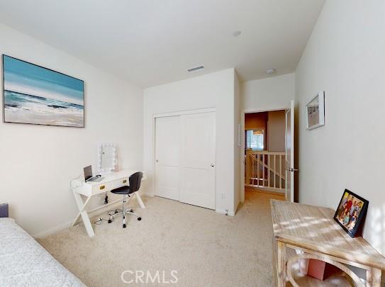 bedroom with light colored carpet and a closet