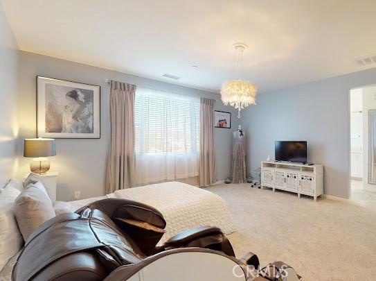 bedroom featuring light carpet and an inviting chandelier