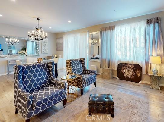 living room featuring an inviting chandelier and light wood-type flooring