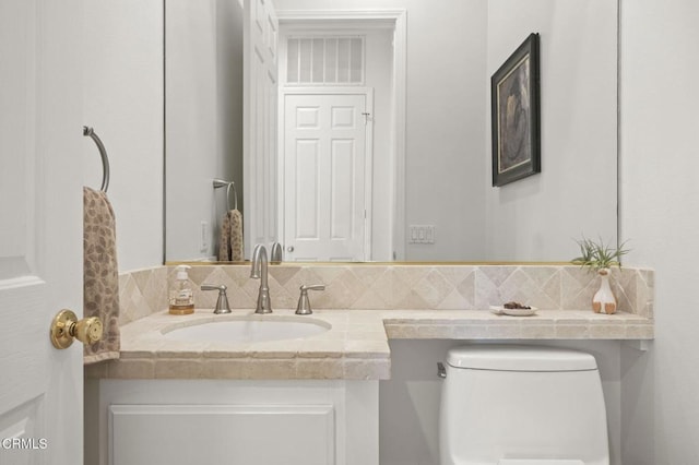 bathroom with toilet, tasteful backsplash, and vanity