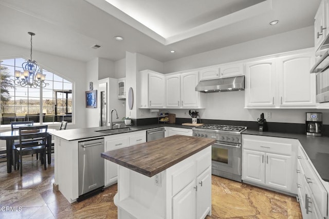 kitchen with a center island, appliances with stainless steel finishes, hanging light fixtures, sink, and white cabinets