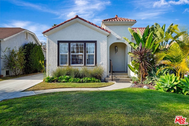 mediterranean / spanish home with a front lawn