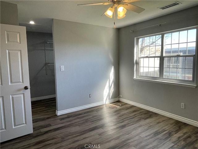 unfurnished room featuring dark wood-type flooring and ceiling fan