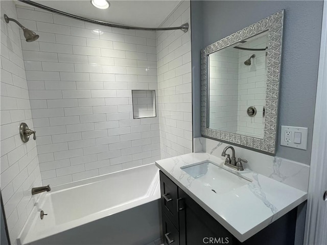 bathroom featuring tiled shower / bath combo and vanity