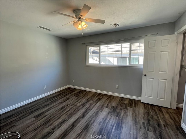 empty room featuring ceiling fan and dark hardwood / wood-style floors