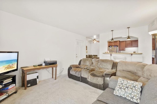 carpeted living room with ceiling fan