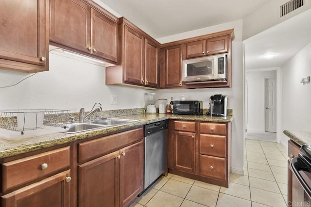 kitchen with light tile patterned floors, visible vents, light stone counters, stainless steel appliances, and a sink