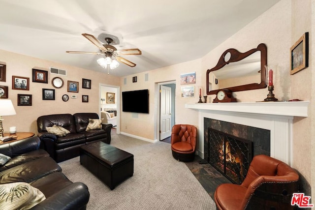 living room featuring ceiling fan and a high end fireplace