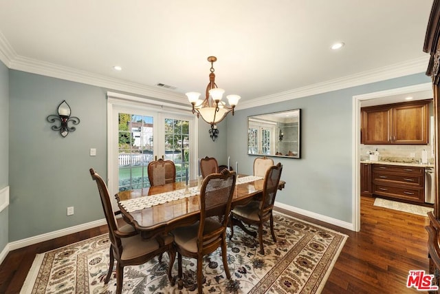 dining space featuring dark hardwood / wood-style flooring, ornamental molding, and an inviting chandelier