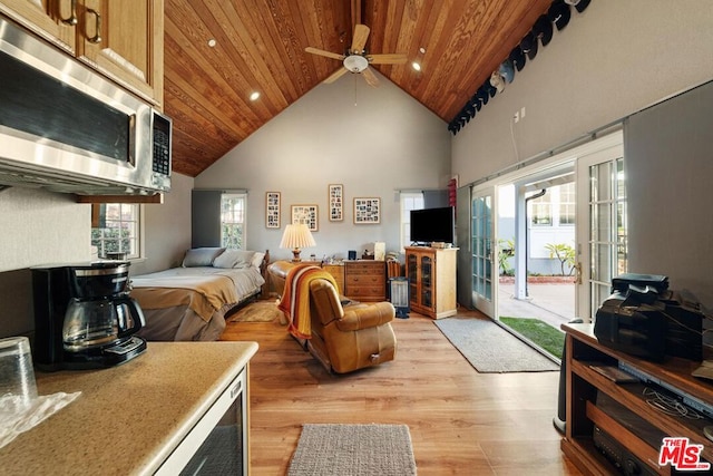 bedroom featuring high vaulted ceiling, multiple windows, access to outside, and light wood-type flooring