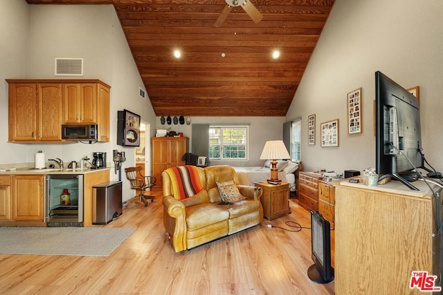 living room featuring beverage cooler, light hardwood / wood-style flooring, and high vaulted ceiling