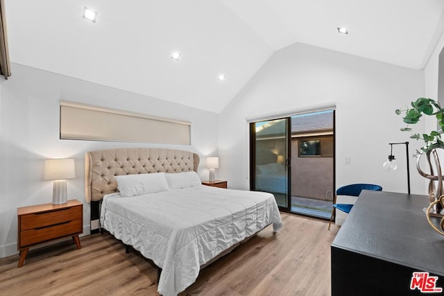 bedroom with hardwood / wood-style flooring, access to exterior, and lofted ceiling