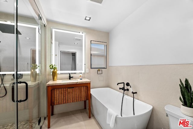 full bathroom featuring toilet, vanity, tile patterned flooring, and independent shower and bath