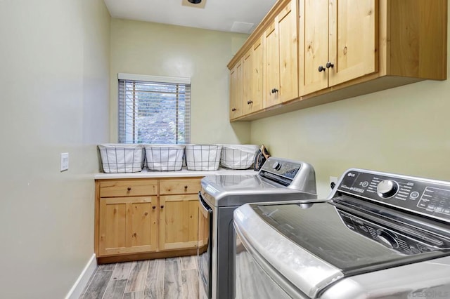 washroom with cabinets and washer and dryer