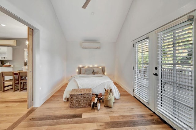 bedroom with light wood-type flooring, access to exterior, a wall unit AC, and ceiling fan