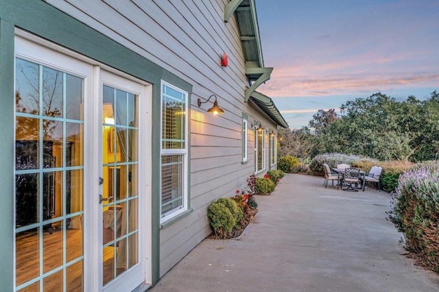 property exterior at dusk with a patio