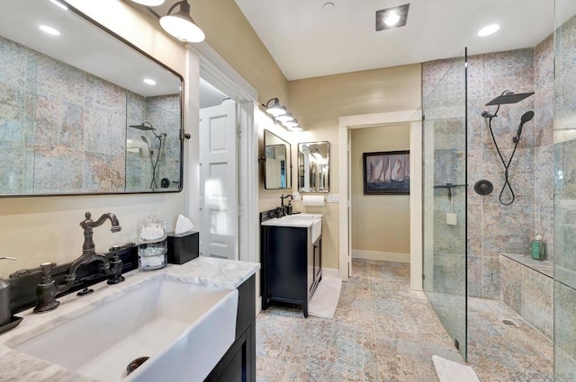 bathroom with tiled shower and vanity