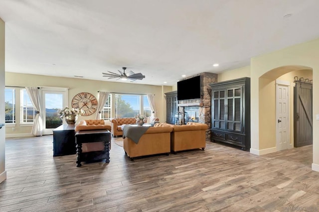 living room with ceiling fan, hardwood / wood-style floors, and a fireplace