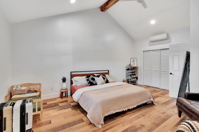 bedroom featuring light hardwood / wood-style flooring, a wall unit AC, ceiling fan, high vaulted ceiling, and beamed ceiling