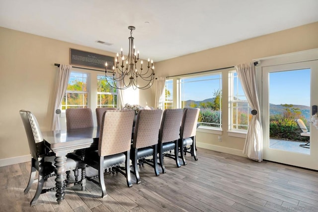 dining space featuring light wood-type flooring, a chandelier, and a mountain view