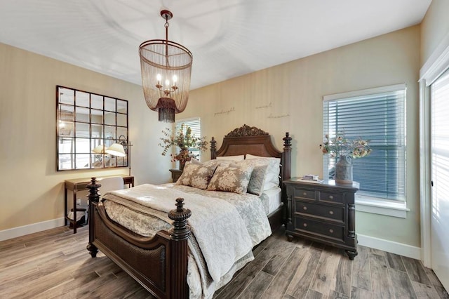 bedroom with hardwood / wood-style floors and a notable chandelier