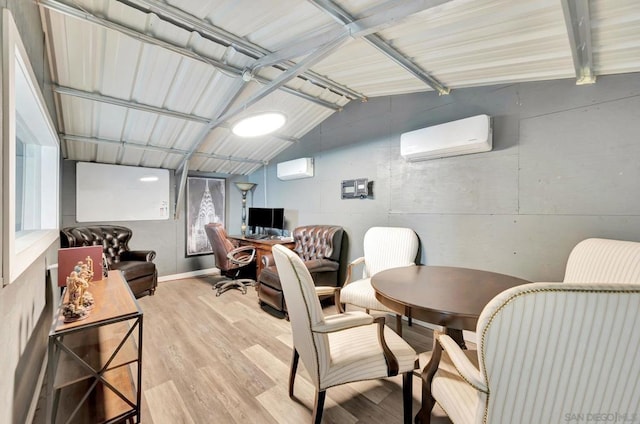 interior space featuring hardwood / wood-style flooring, a wall unit AC, and lofted ceiling