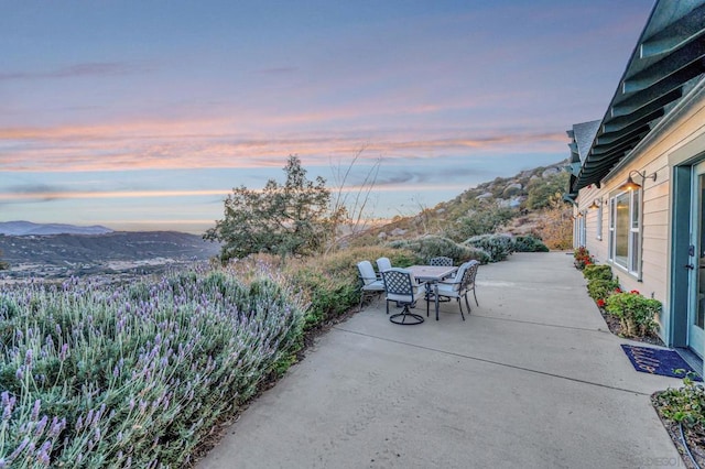 patio terrace at dusk featuring a mountain view