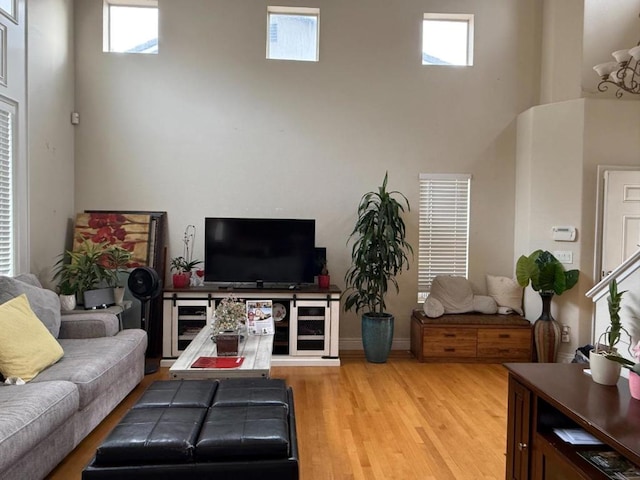 living room featuring a high ceiling and light wood-type flooring