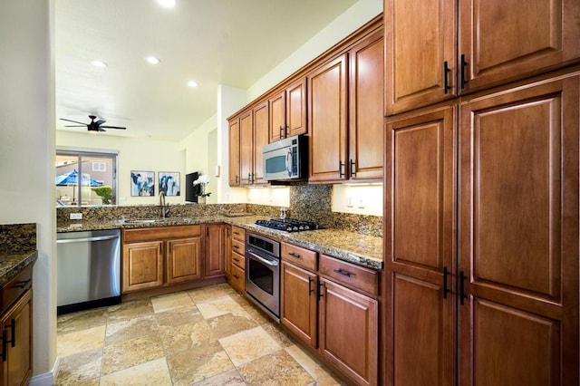 kitchen with ceiling fan, backsplash, dark stone countertops, sink, and stainless steel appliances