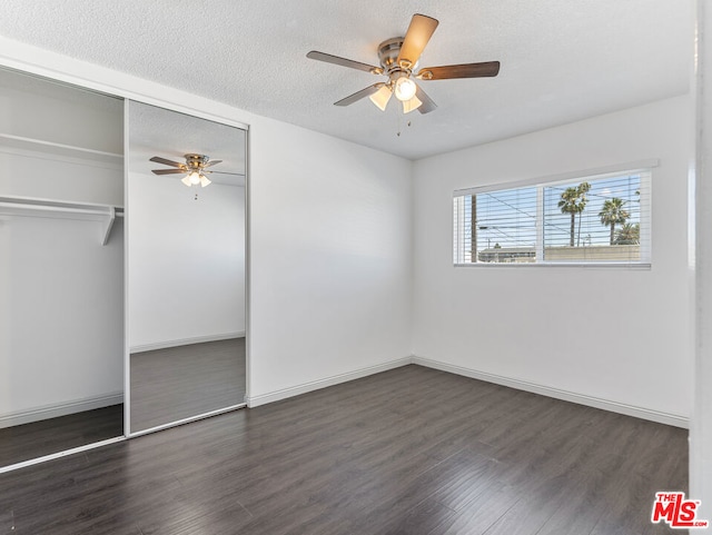 unfurnished bedroom featuring dark wood-type flooring, ceiling fan, a closet, and a textured ceiling