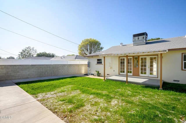 view of yard with central air condition unit, french doors, and a patio