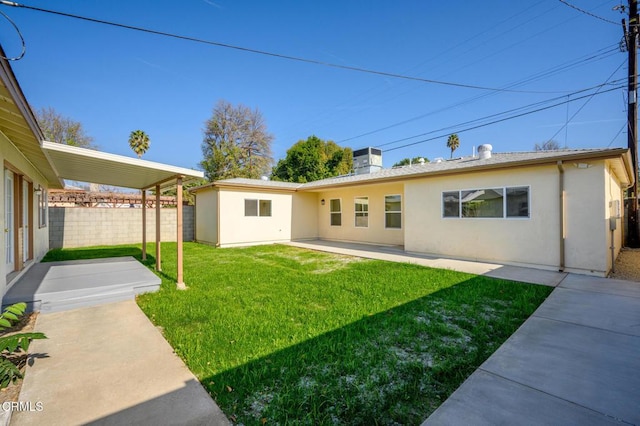 back of house featuring a lawn, central AC, and a patio