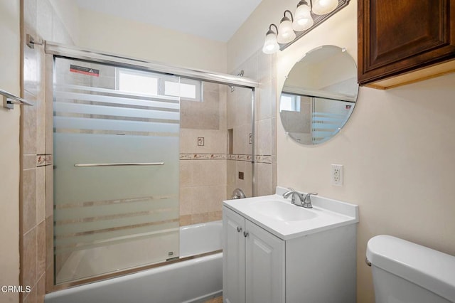 full bathroom featuring toilet, vanity, and shower / bath combination with glass door