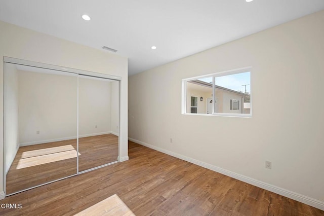 unfurnished bedroom featuring a closet and hardwood / wood-style flooring