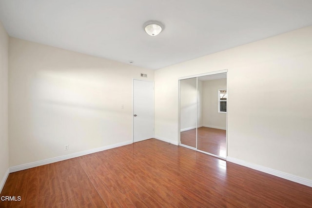 unfurnished bedroom with a closet and hardwood / wood-style flooring