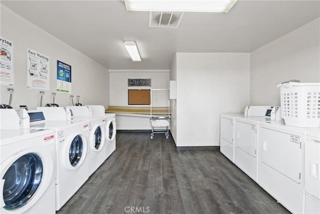 laundry room with dark wood-type flooring and separate washer and dryer