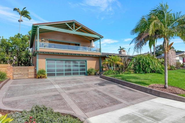 view of front of property featuring a balcony, a garage, and a front lawn