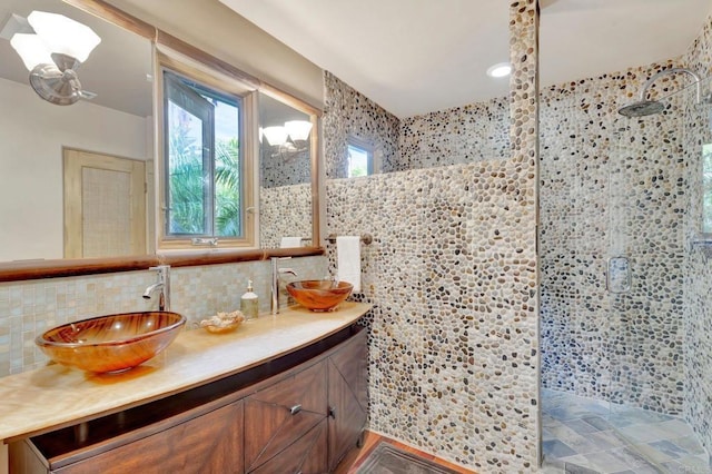 bathroom with tile walls, vanity, and walk in shower