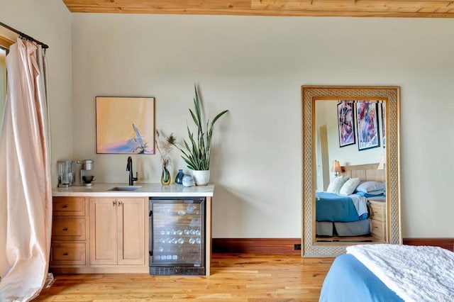 bedroom featuring wine cooler, indoor wet bar, and light wood-type flooring