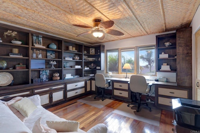 office featuring hardwood / wood-style flooring, brick ceiling, and ceiling fan