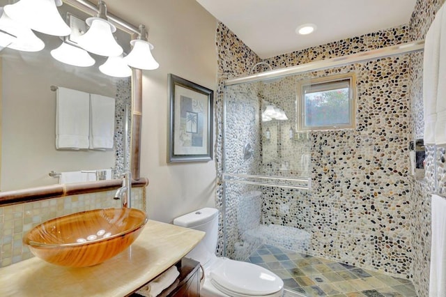 bathroom featuring tasteful backsplash, vanity, toilet, a shower with door, and an inviting chandelier