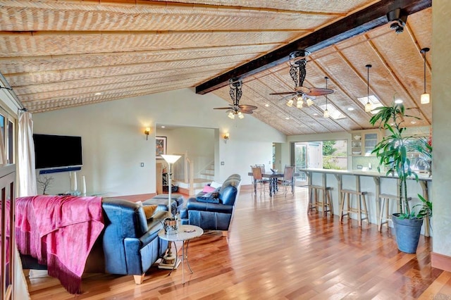 living room with beam ceiling, hardwood / wood-style flooring, high vaulted ceiling, and ceiling fan